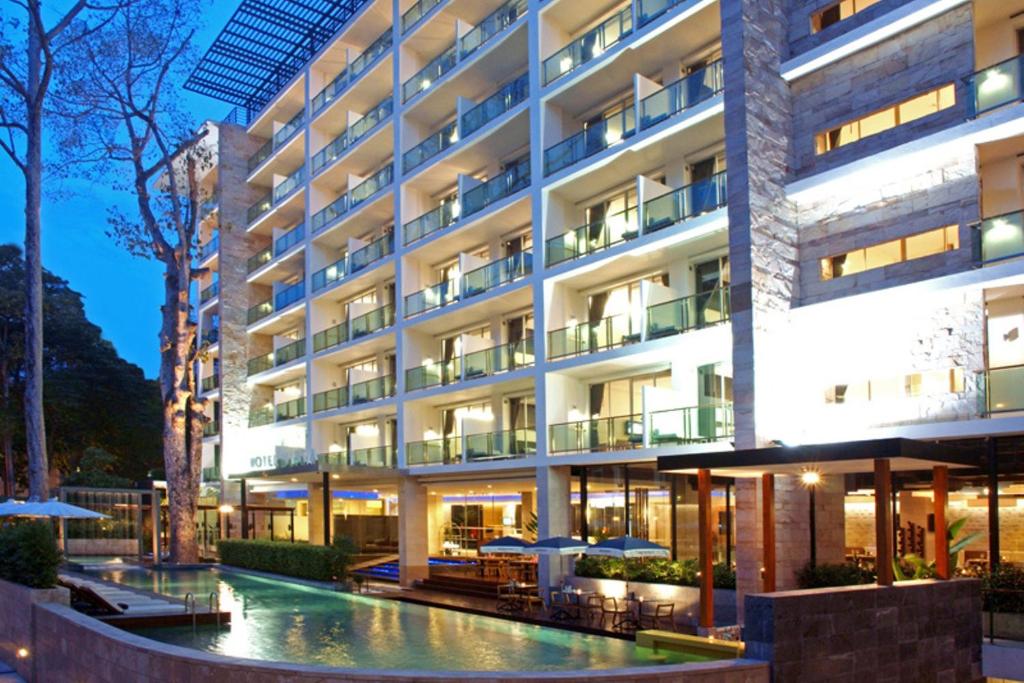 a hotel with a pool in front of a building at Hotel Vista in Pattaya Central