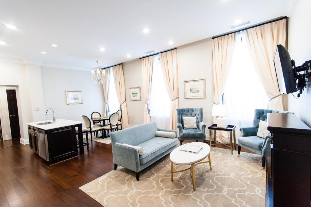 a living room with a blue couch and chairs at Sydney Boutique Inn & Suites in Charlottetown