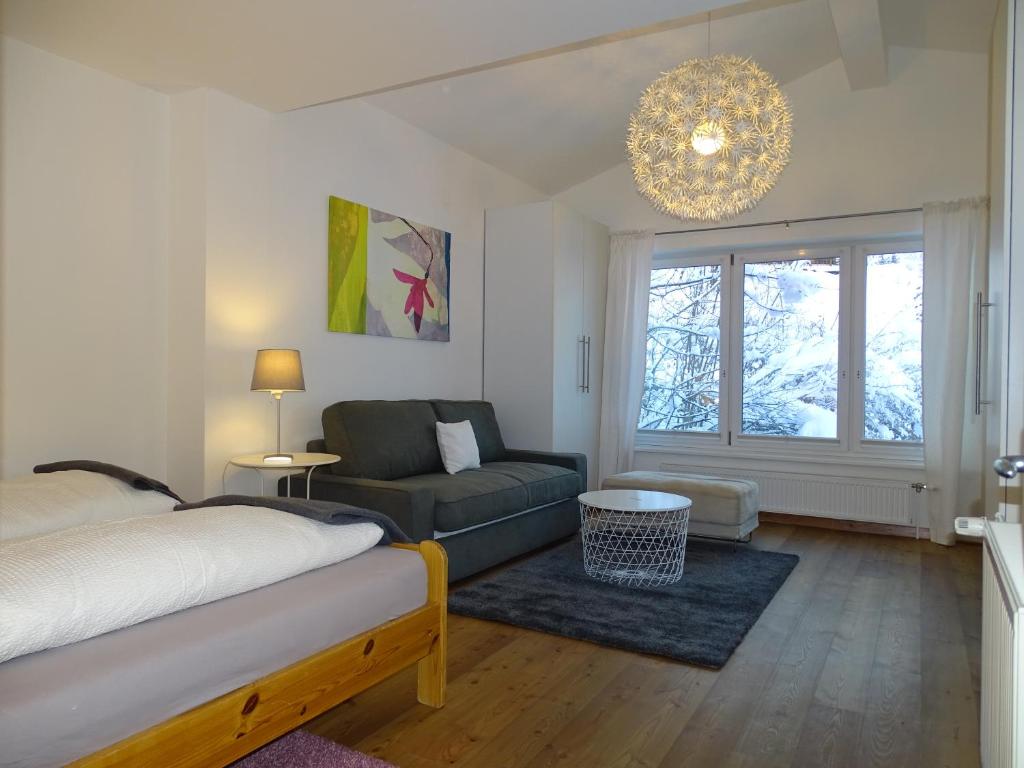 sypialnia z łóżkiem, kanapą i żyrandolem w obiekcie Alpine Cottage Salzburg w mieście Maria Alm am Steinernen Meer