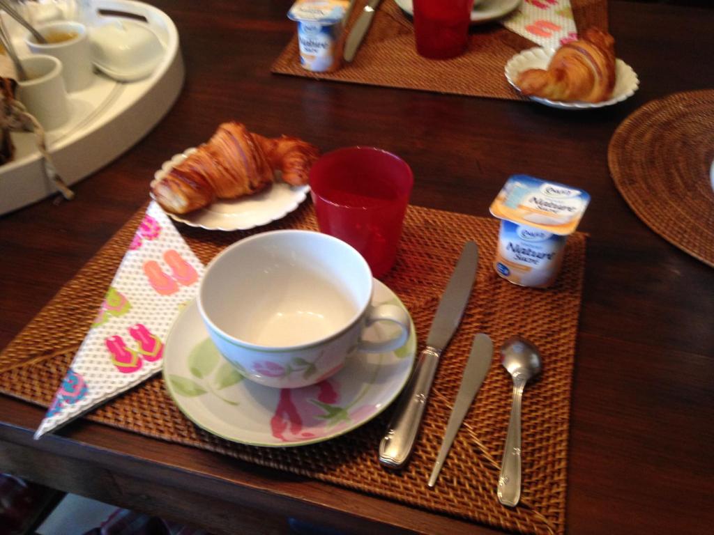 a table topped with a cup of coffee and croissants at Les Fleurs in Monpazier