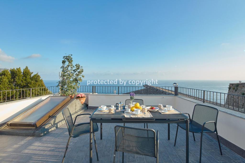 una mesa y sillas en un balcón con vistas al océano en Luxury Penthouse Sea View, en Corniglia