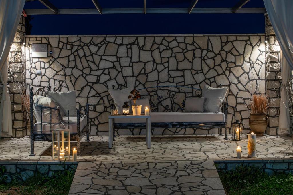 a stone wall with a bench and candles on a patio at A Ponte Studios & Apartments in Sykia Chalkidikis