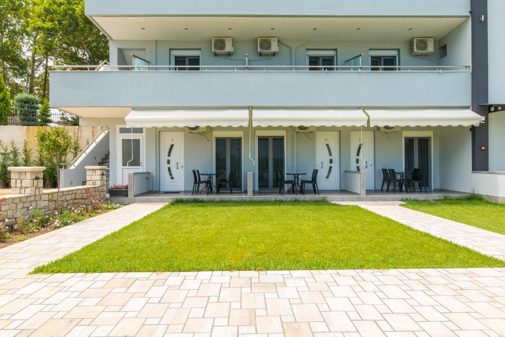 a house with a lawn in front of it at A Ponte Studios & Apartments in Sykia Chalkidikis