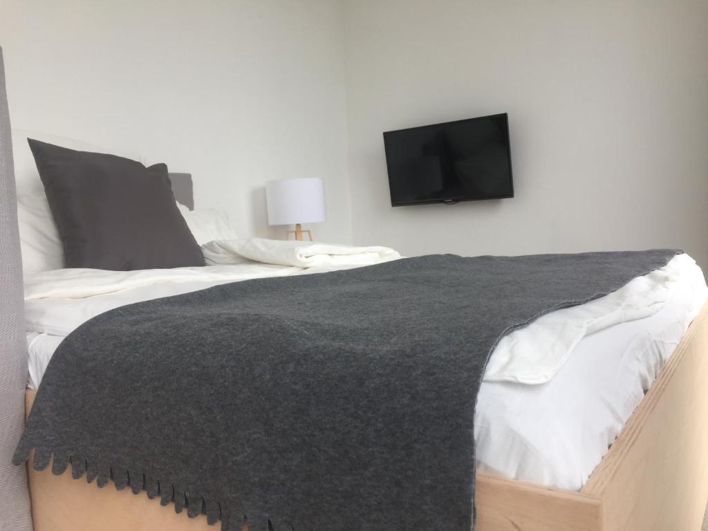 a bedroom with a bed with a tv on the wall at Designer Studio Geestland in Langen