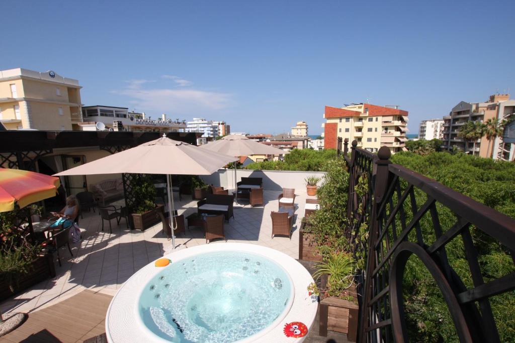 uma banheira de hidromassagem numa varanda com vista para a cidade em Hotel Naxos B&B em Alba Adriatica