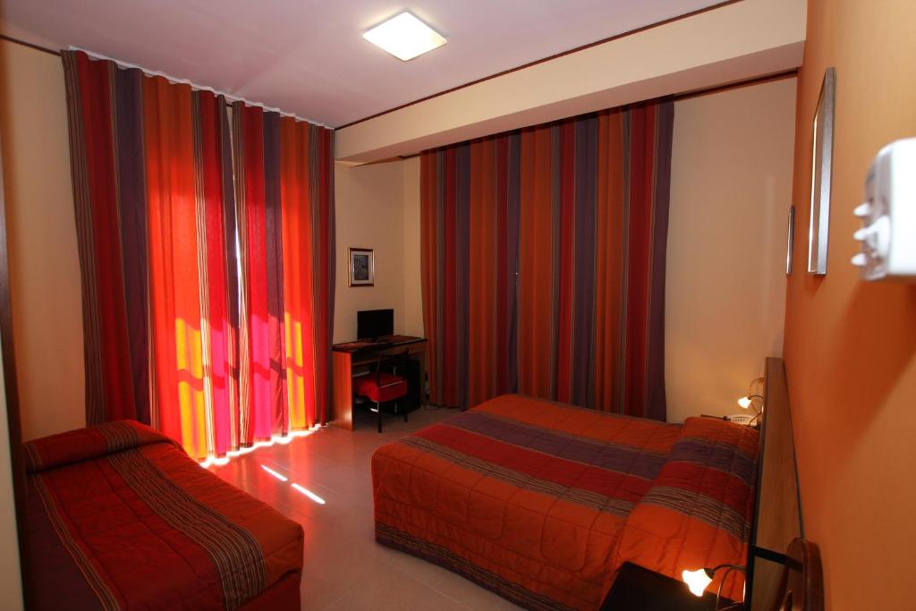A bed or beds in a room at Hotel Naxos B&B