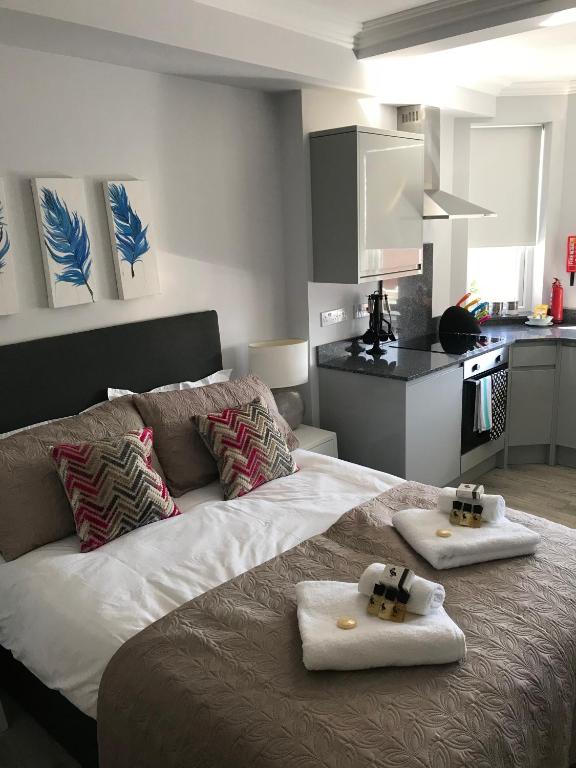 a bedroom with a bed with two towels on it at Berkshire Serviced Apartment Helena 12 in Reading