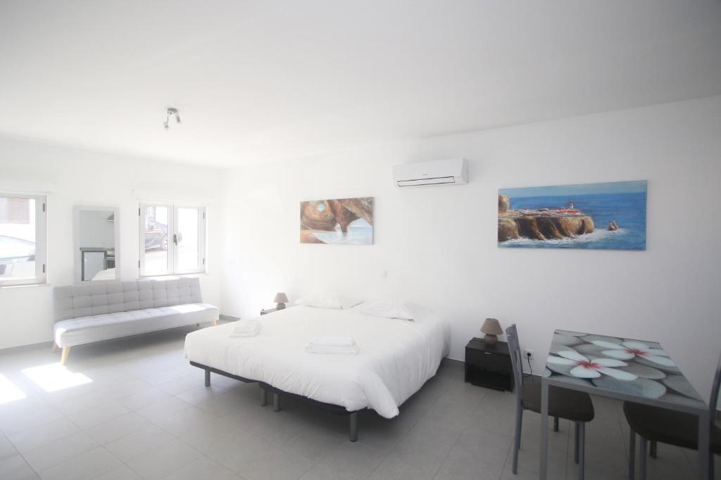 um quarto branco com uma cama e uma mesa em Guest House Lovely Swan em Lagos