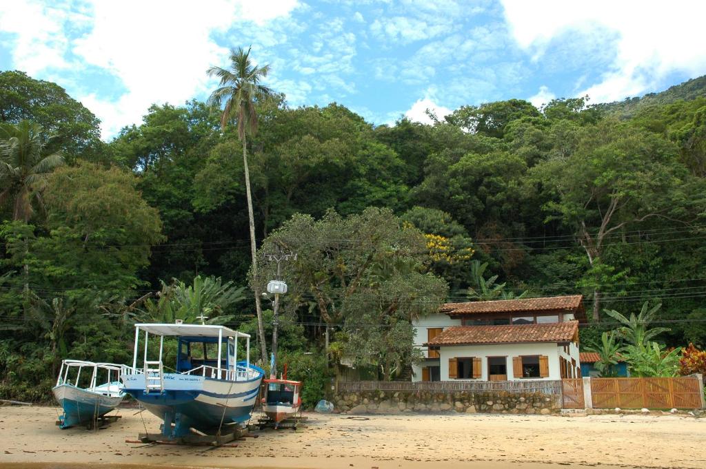 dos barcos están estacionados frente a una casa en Casa do Canto en Ilha Grande