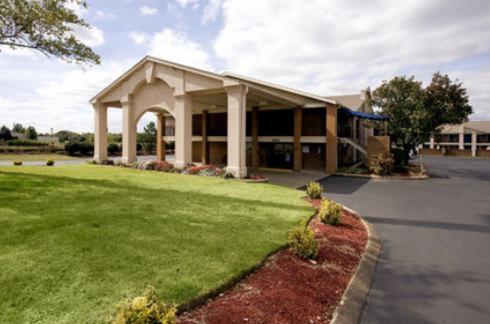 Americas Best Value Inn & Suites in Murfreesboro في مورفريسبورو: مبنى أمامه حديقة خضراء