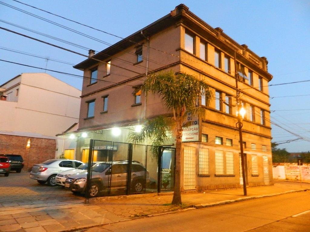 un edificio en una calle con coches aparcados delante en Hotel Ivo De Conto, en Porto Alegre