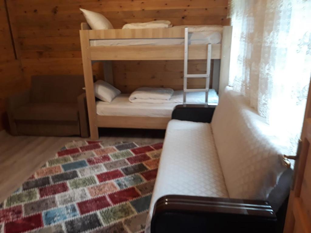 ウズンギョルにあるKatipogulları Apartの二段ベッド2台とソファが備わる客室です。