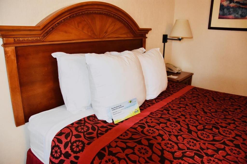 a hotel room with a bed with white pillows at Days Inn by Wyndham Las Cruces in Las Cruces
