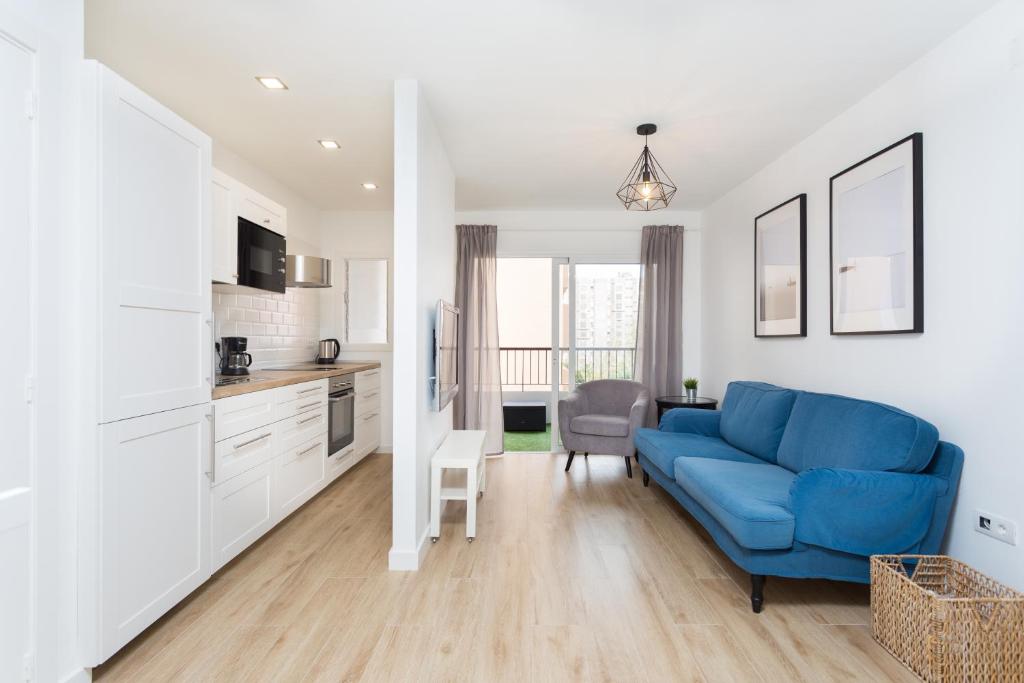 sala de estar con sofá azul y cocina en Modern Center Apartment, en Santa Cruz de Tenerife