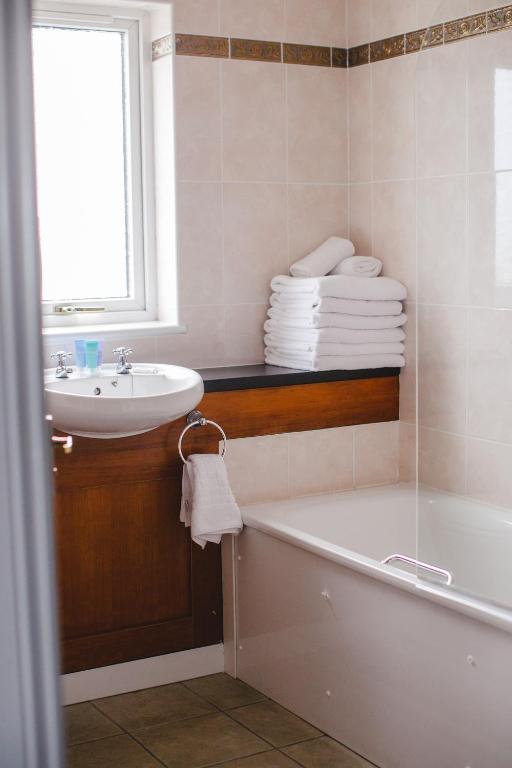 a bathroom with a sink and a bath tub and a sink at Inn On The Coast in Portrush