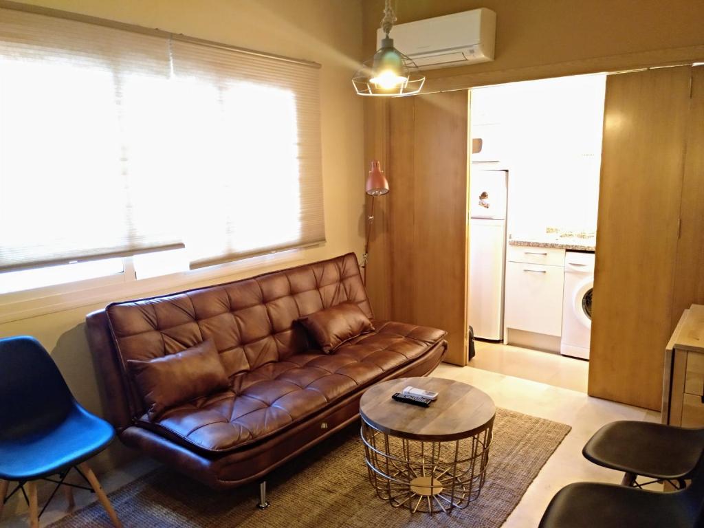 マラガにあるSan Rafael 2 RooMalaga by Bossh! Apartmentsのリビングルーム(茶色の革張りのソファ、テーブル付)