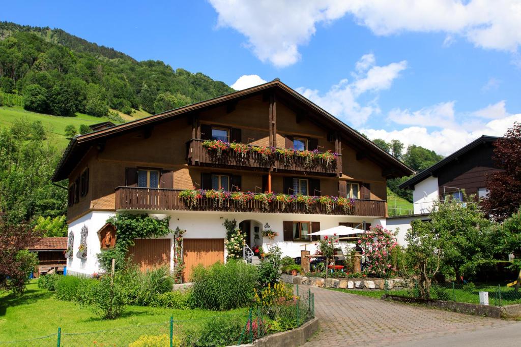 ein Haus mit einem Balkon mit Blumen darauf in der Unterkunft Apartment Am Bach in Mellau