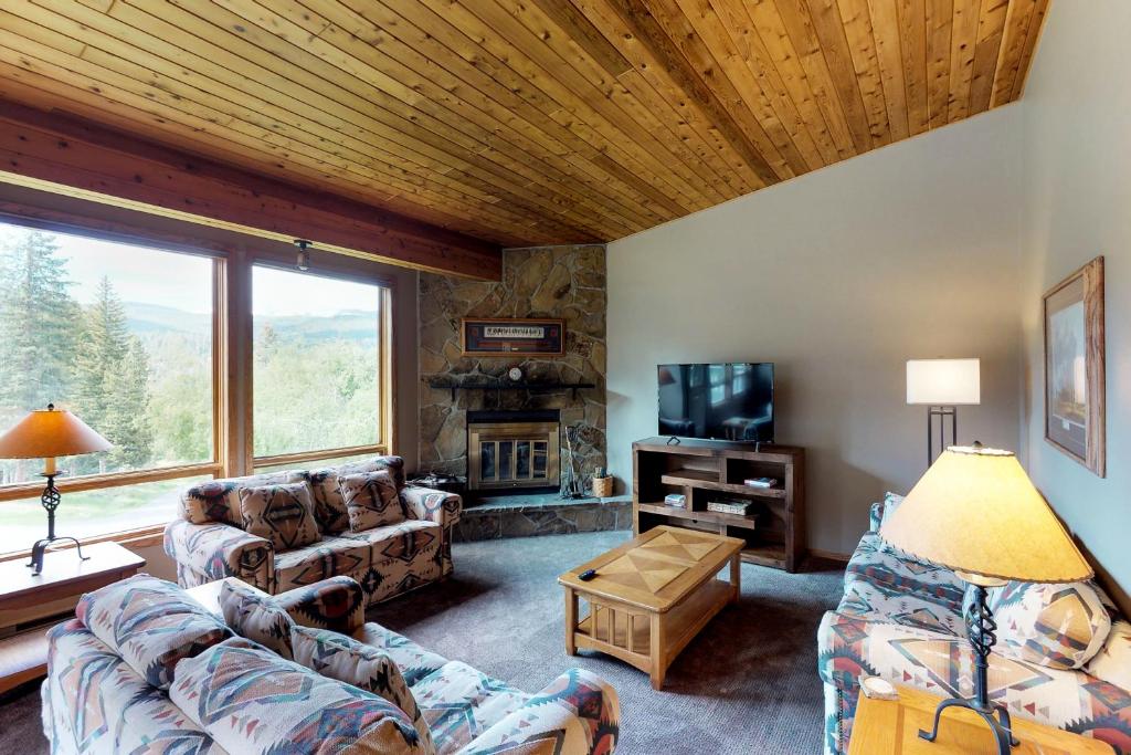 Una sala de estar con un sofá y un televisor. en Hidden Village 700, en Big Sky
