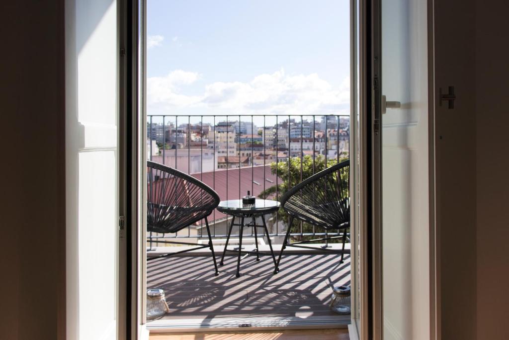 uma vista para uma varanda com uma mesa e cadeiras em Destino Lisboa Apartments em Lisboa