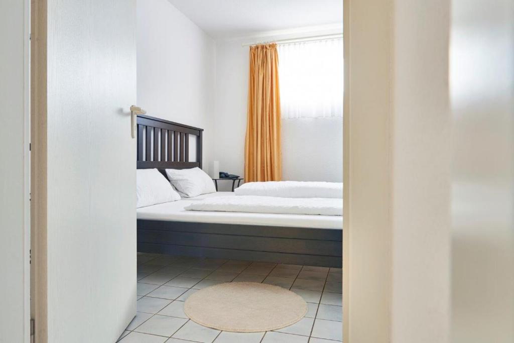 1 dormitorio con cama y ventana en Hotel Asslar, en Aßlar