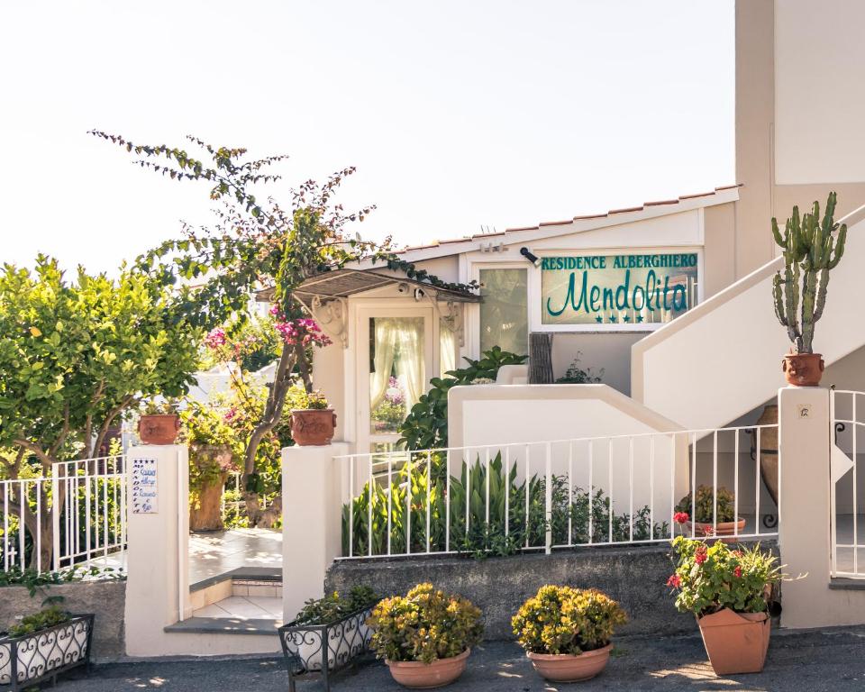 a building with potted plants in front of it at Hotel Residence Mendolita in Lipari