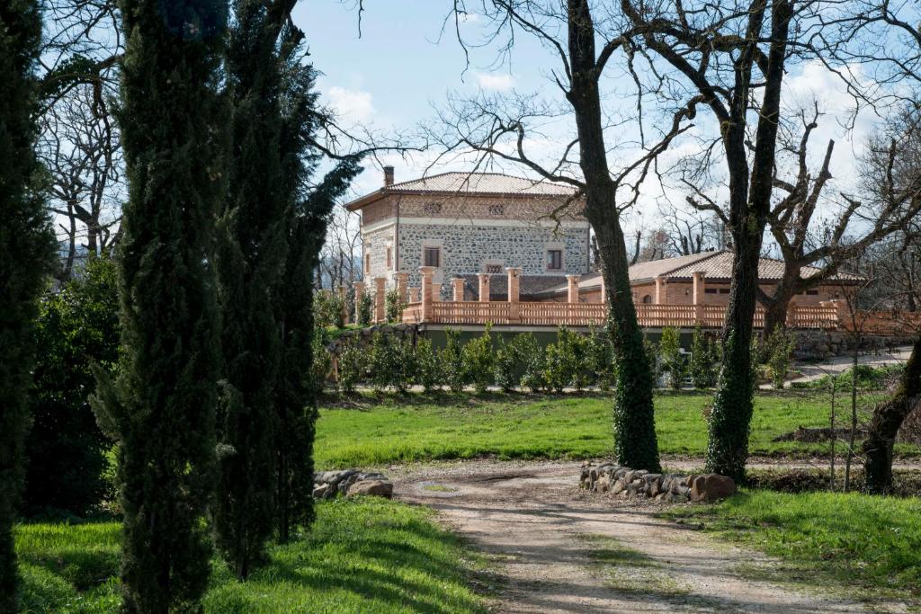 a large building in the middle of a field with trees at La Tenuta di Trimalcione in Pofi