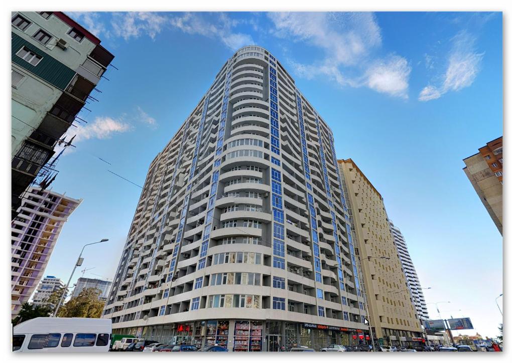 wysoki budynek w mieście z niebieskim niebem w obiekcie apartaments on avtandil w mieście Batumi