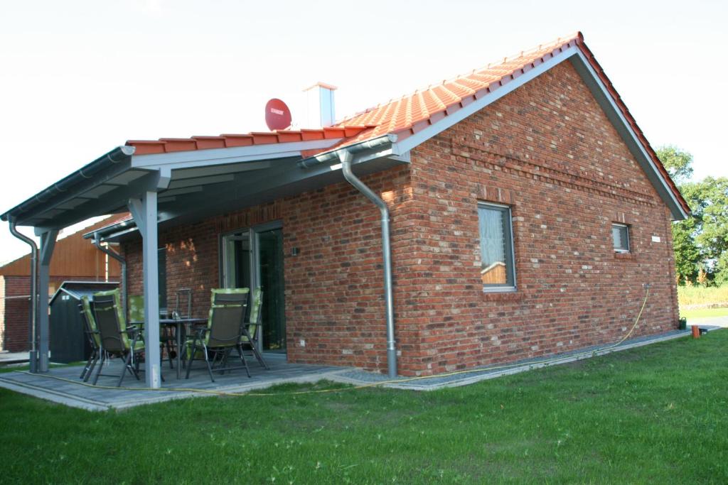 una casa de ladrillo rojo con mesa y sillas en Holunder Hüsken, en Oberlangen
