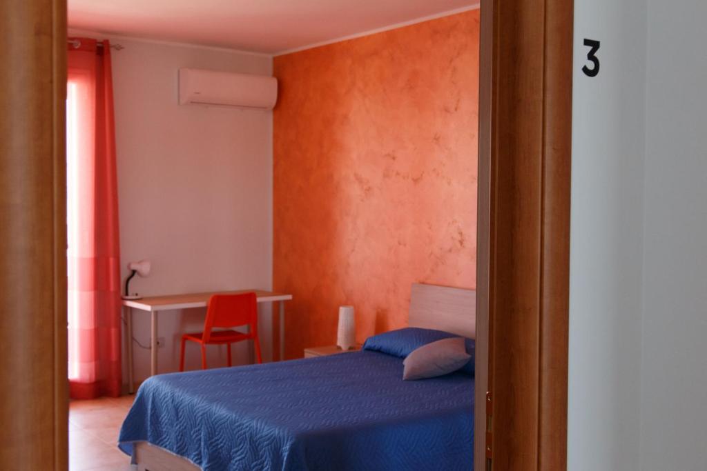 フロリーディアにあるB&B Mediterraneoのベッドルーム(青いベッド1台、赤い椅子付)