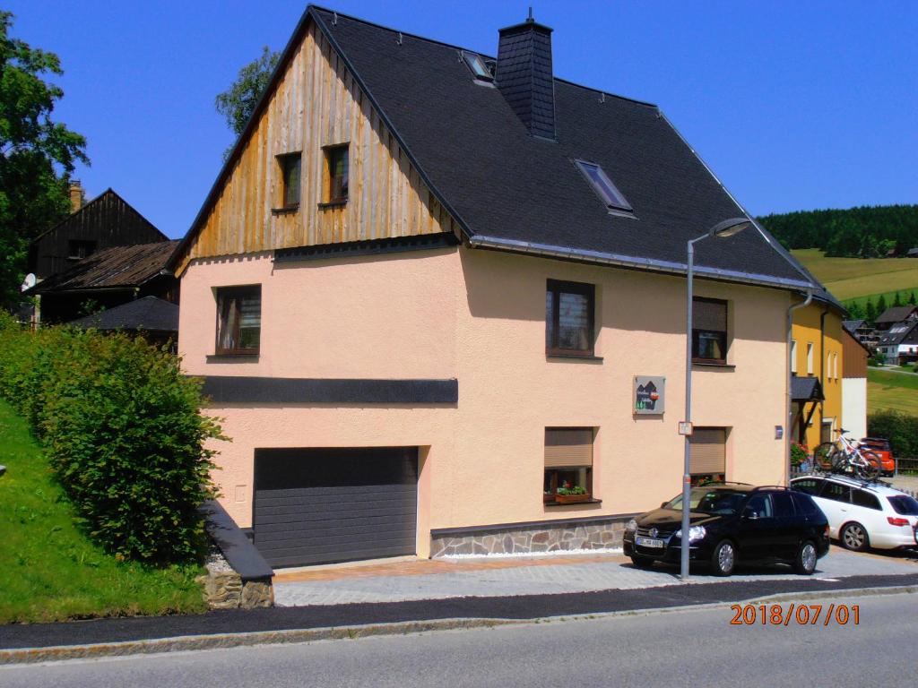 ein großes Haus mit einer Garage und einem Auto davor geparkt in der Unterkunft Ferienhaus Fichtelberg in Kurort Oberwiesenthal