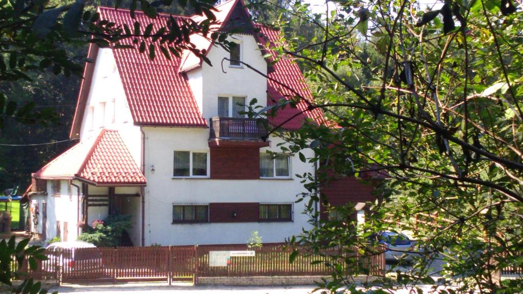a large white house with a red roof at Domlesny in Kiczora