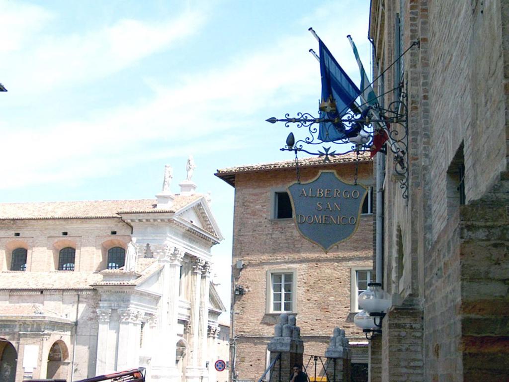 un panneau indiquant un restaurant sur le côté d'un bâtiment dans l'établissement Albergo San Domenico, à Urbino