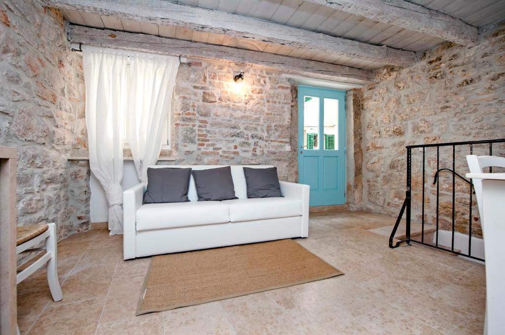 a living room with a white couch and a blue door at Apartments CASA ROCCIA BIANCA in Rovinj