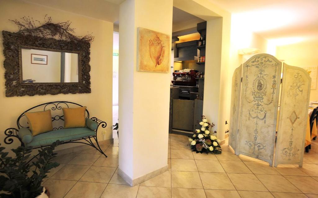 a hallway with a green chair and a mirror at Hotel Riviera Blu in Tirrenia