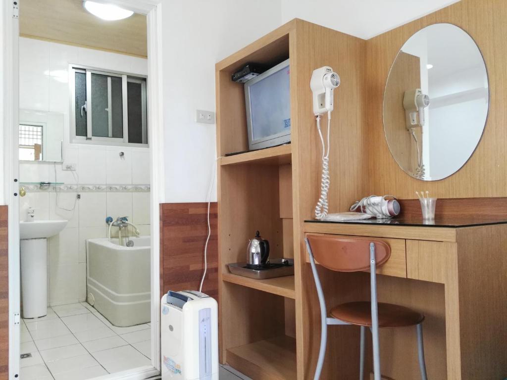 a bathroom with a desk with a sink and a mirror at Qun Feng Hotel in Fenqihu