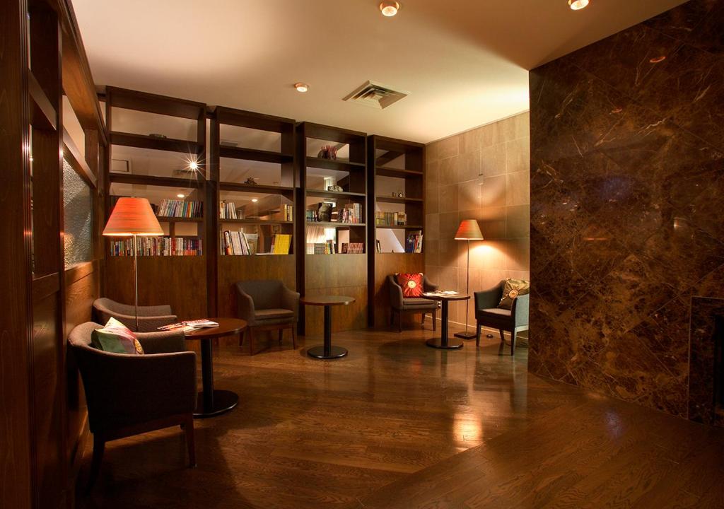 a lobby with tables and chairs in a room at Hotel Hanaan in Nikko