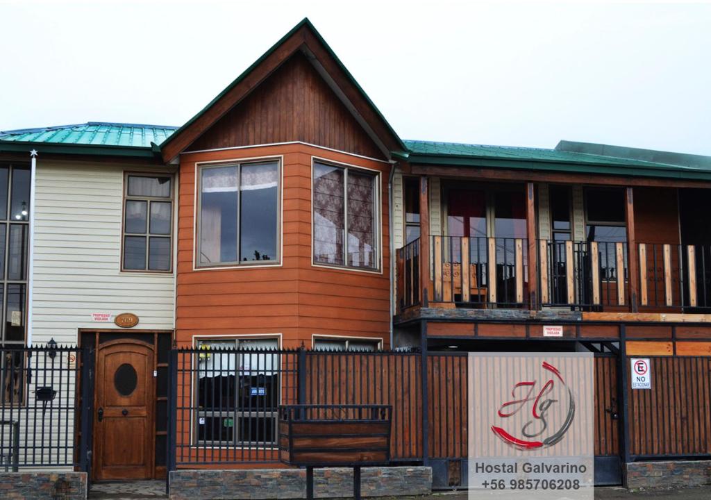 a house with a fence and a bench in front of it at Hostal Galvarino Puerto Natales in Puerto Natales