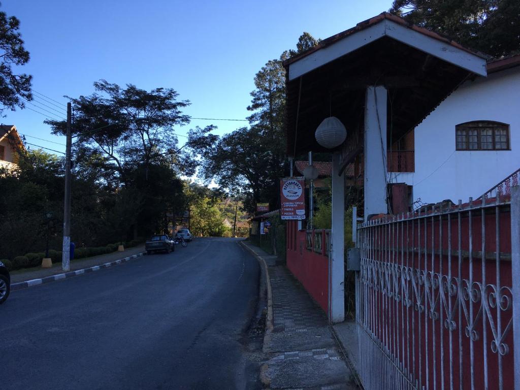 un edificio junto a una carretera con una valla en Pousada Nihhon, en Santo Antônio do Pinhal