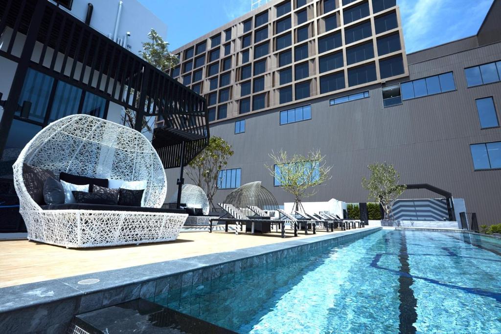 uma piscina de hotel com uma fonte ao lado de um edifício em Chezzotel Pattaya em Pattaya Central