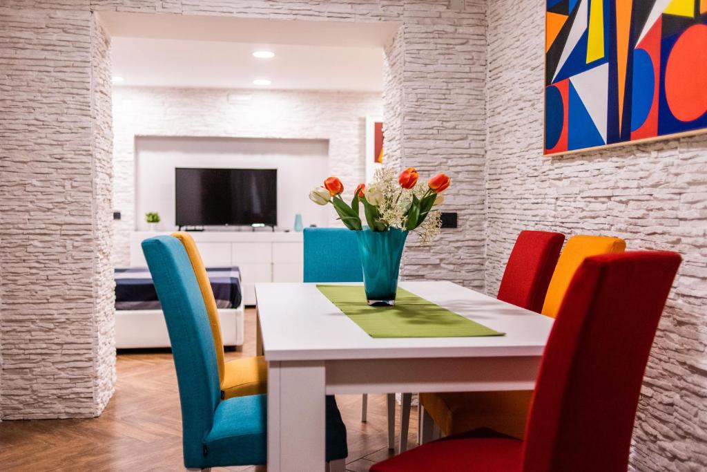 jadalnia ze stołem i kolorowymi krzesłami w obiekcie AVG CityCenter Apartments w mieście Palermo