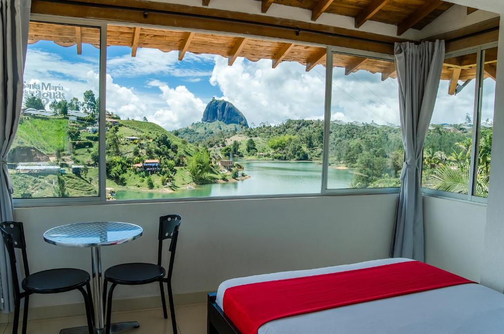 a bedroom with a window with a view of a river at Hotel Santa Maria de las Aguas Peñol in Guatapé