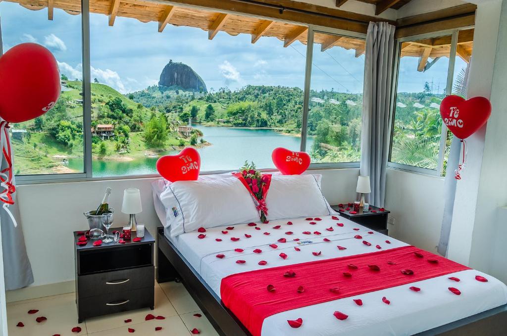 een slaapkamer met een groot raam met harten op het bed bij Hotel Santa Maria de las Aguas Peñol in Guatapé