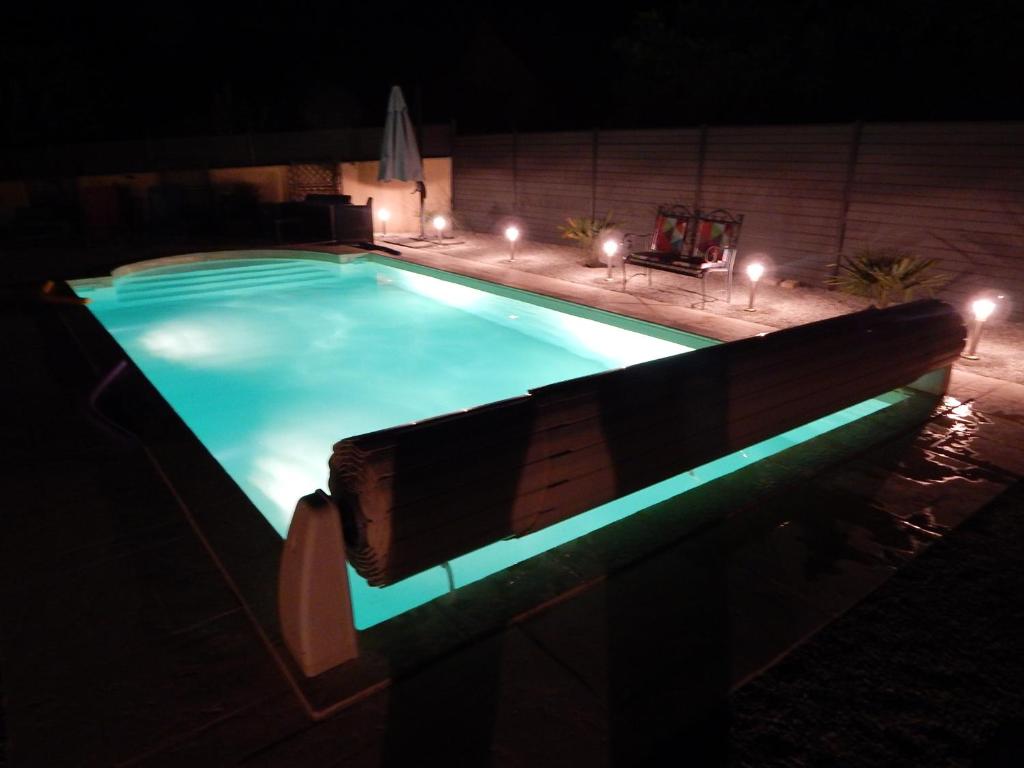 a swimming pool with a bench in the dark at Audionnière in Saint-Gervais en-Belin