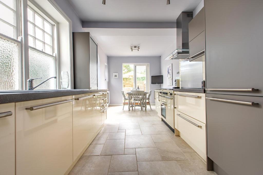 a kitchen with white cabinets and a table in it at Alton House - The Annexe in Sheringham