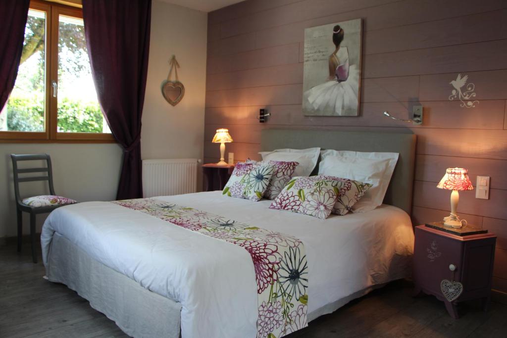 a bedroom with a large white bed with pillows at Gîte d'Anne et Ulysse in Sept-Frères