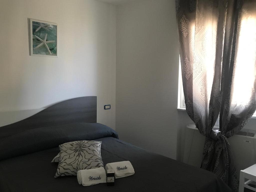 a bedroom with a bed with two pillows and a window at Nereide in Tropea