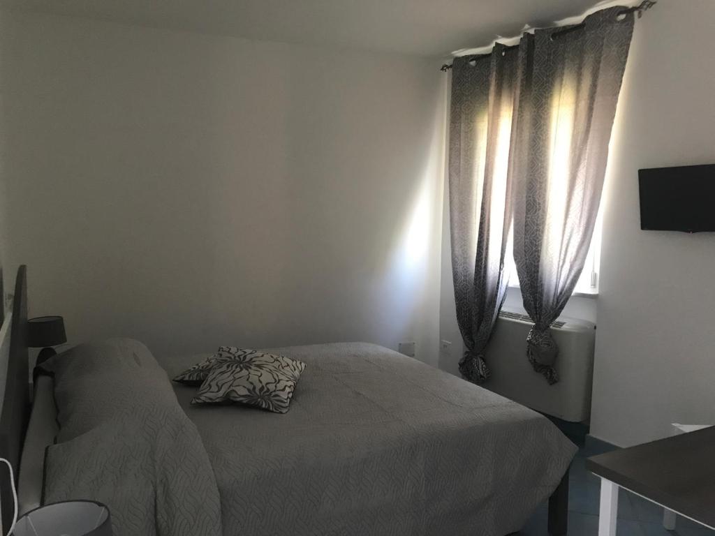 a bedroom with a bed and a window with curtains at Nereide in Tropea