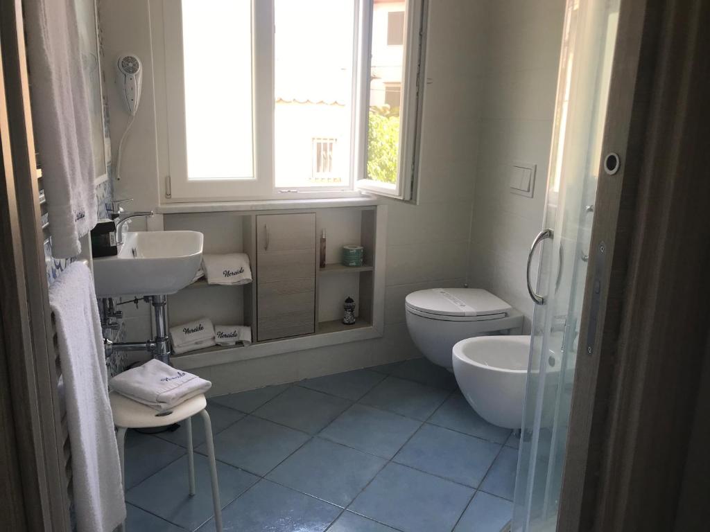 a bathroom with a toilet and a sink and a window at Nereide in Tropea