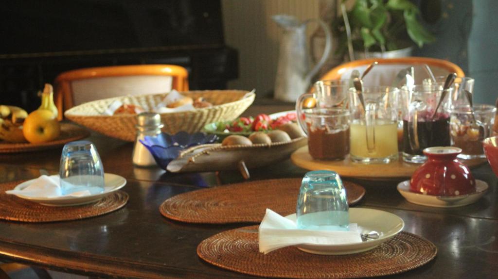 a table with plates and bowls of food and drinks at La Ferme de Thoudiere in Saint-Étienne-de-Saint-Geoirs