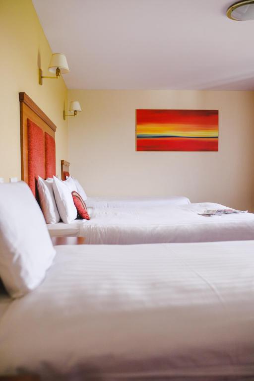 two beds sitting next to each other in a room at Inn On The Coast in Portrush